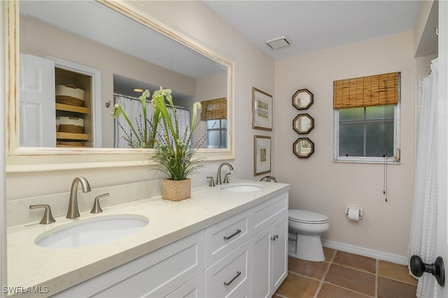 bathroom with tile patterned flooring, vanity, and toilet