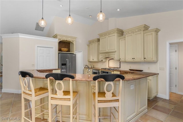 kitchen with decorative backsplash, high quality fridge, vaulted ceiling, dark stone countertops, and cream cabinetry