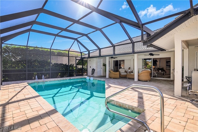 view of swimming pool featuring outdoor lounge area, ceiling fan, a patio area, and glass enclosure