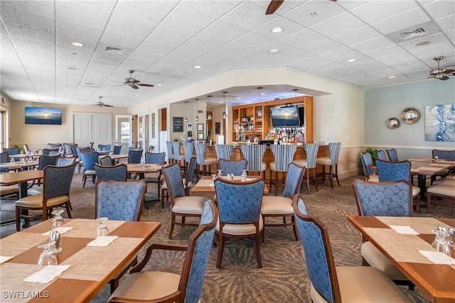 dining space featuring dark colored carpet and ceiling fan