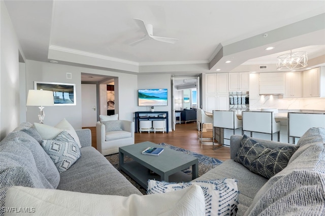 living room featuring crown molding, dark hardwood / wood-style flooring, and ceiling fan with notable chandelier