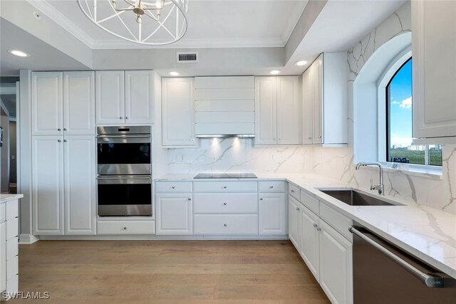 kitchen with white cabinetry, sink, stainless steel appliances, light hardwood / wood-style flooring, and ornamental molding