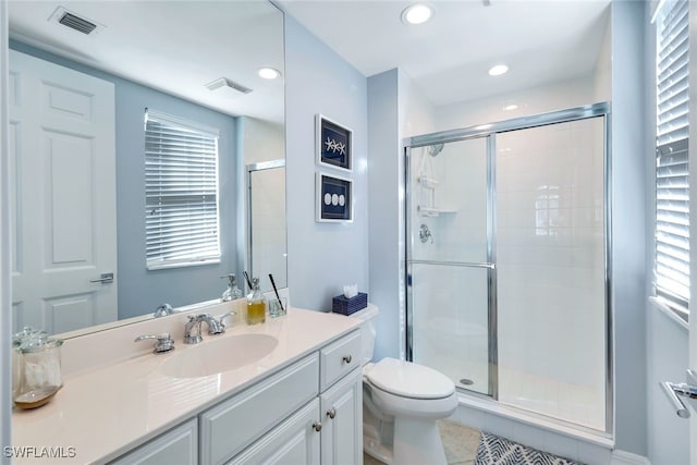 bathroom with tile patterned floors, vanity, toilet, and walk in shower