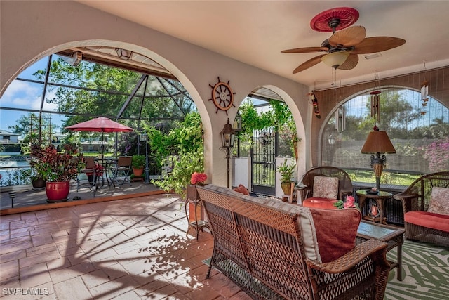 view of patio with glass enclosure and ceiling fan