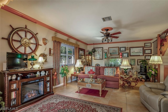 sitting room featuring ceiling fan, light tile patterned flooring, and ornamental molding