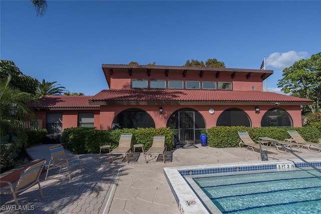 rear view of house featuring a patio area and a community pool