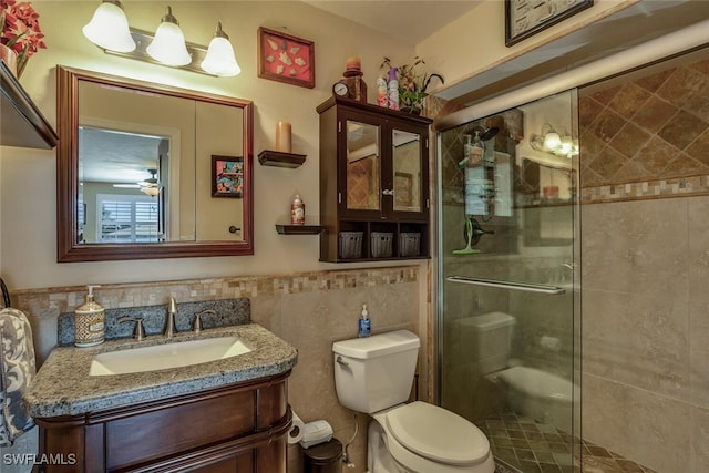 bathroom with vanity, toilet, tile walls, and walk in shower