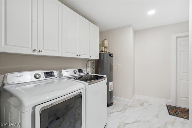 washroom featuring cabinets, washing machine and dryer, and water heater