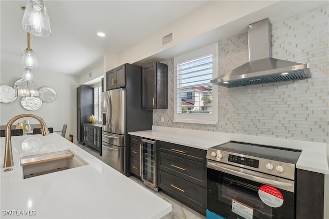 kitchen with backsplash, wall chimney exhaust hood, stainless steel appliances, decorative light fixtures, and wine cooler