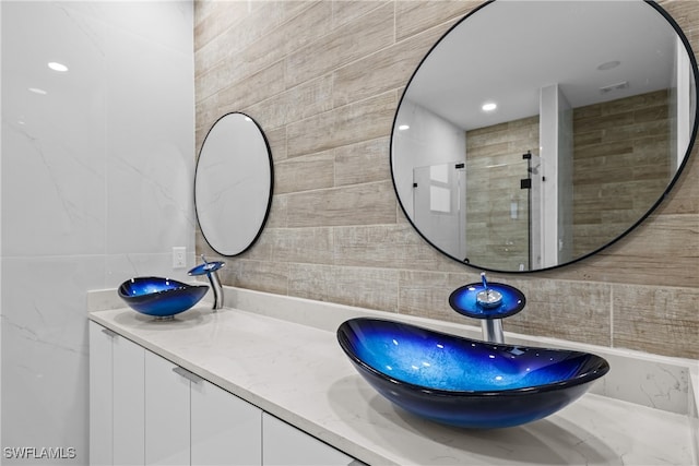 bathroom featuring tasteful backsplash, vanity, and tile walls