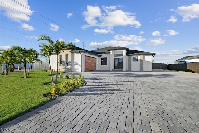 view of front of home featuring a front yard and a garage