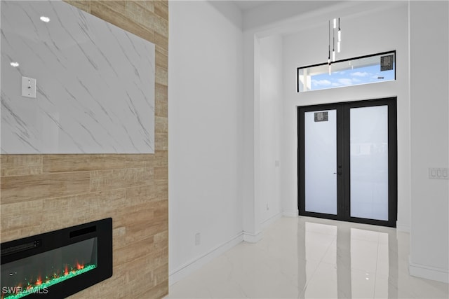 foyer featuring french doors and a tiled fireplace