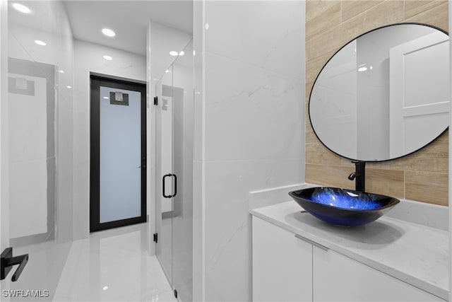 bathroom with walk in shower, vanity, tile walls, and basketball hoop