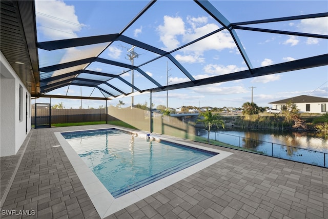 view of pool featuring a lanai, a patio area, and a water view