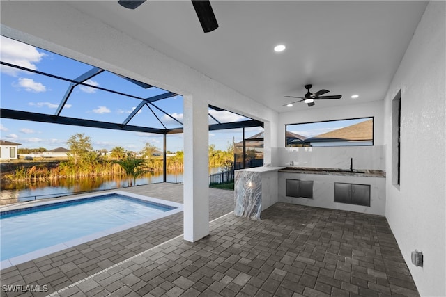 view of pool with ceiling fan, a lanai, a patio, and a water view