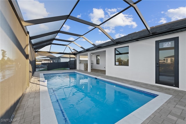 view of swimming pool with glass enclosure and a patio area