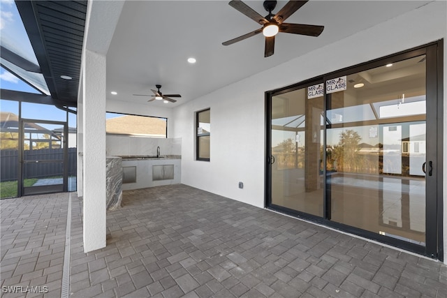 view of patio / terrace featuring ceiling fan, exterior kitchen, and sink