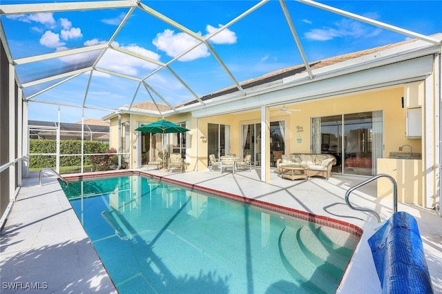 view of swimming pool featuring ceiling fan, a lanai, and a patio