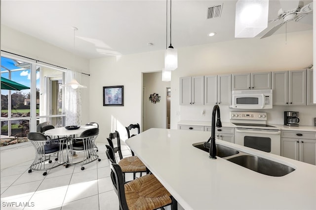 kitchen with gray cabinetry, decorative light fixtures, and white appliances