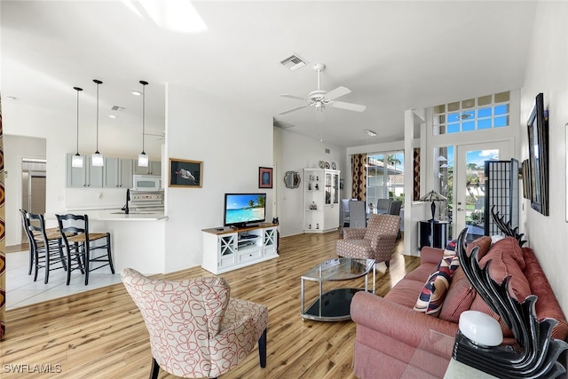 living room with ceiling fan and light wood-type flooring