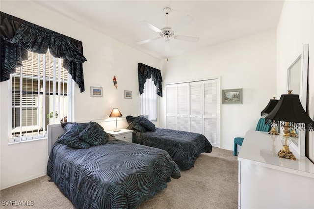 carpeted bedroom with ceiling fan and a closet