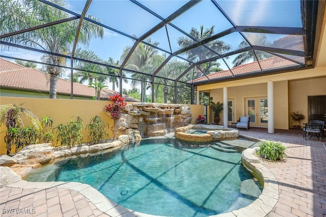 view of swimming pool with french doors, pool water feature, a lanai, an in ground hot tub, and a patio