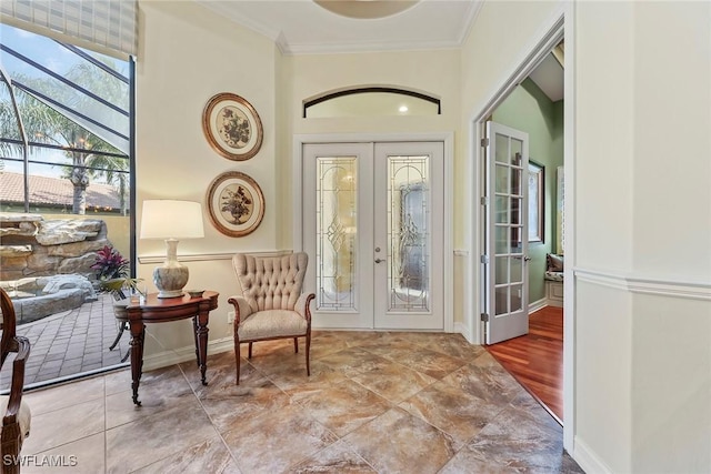 foyer featuring french doors, light hardwood / wood-style floors, and crown molding