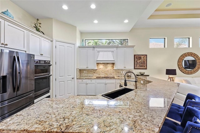 kitchen featuring light stone countertops, appliances with stainless steel finishes, and sink