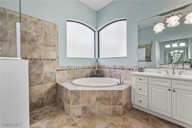 bathroom with tiled tub, a wealth of natural light, and vanity