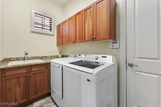 washroom featuring cabinets, washer and clothes dryer, and sink