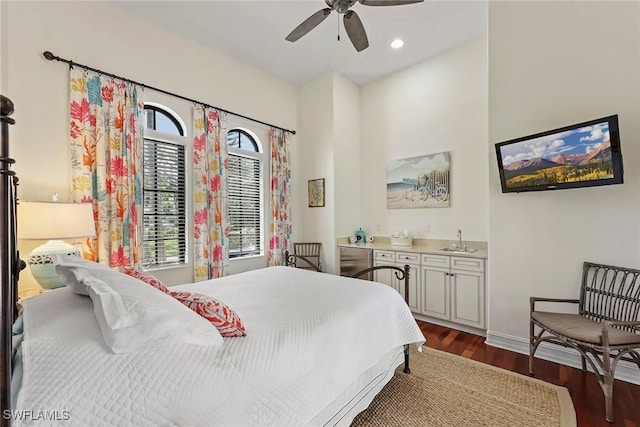 bedroom with multiple windows, ceiling fan, sink, and dark hardwood / wood-style floors