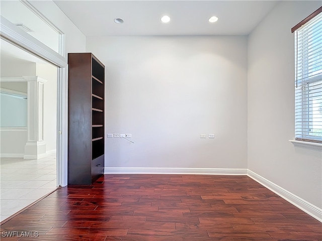 unfurnished room with dark hardwood / wood-style flooring and plenty of natural light