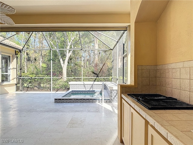 view of patio featuring an in ground hot tub, ceiling fan, and a lanai