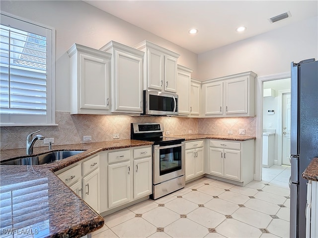 kitchen featuring decorative backsplash, sink, white cabinets, and appliances with stainless steel finishes