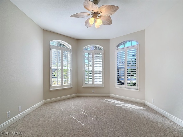 carpeted spare room with ceiling fan