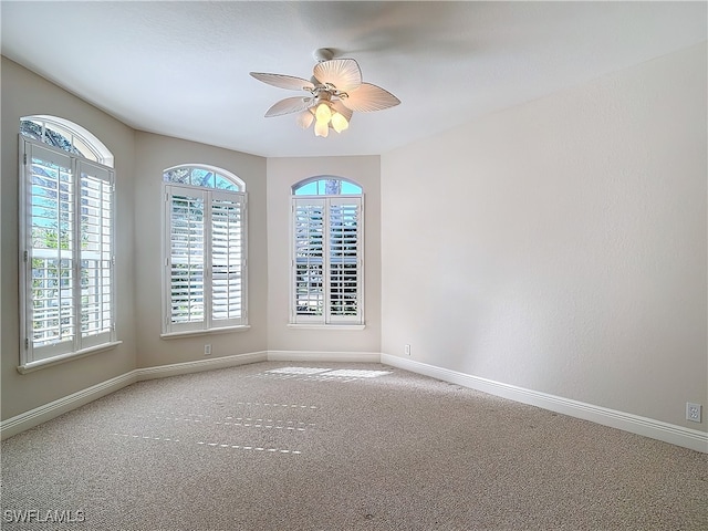 carpeted spare room with ceiling fan