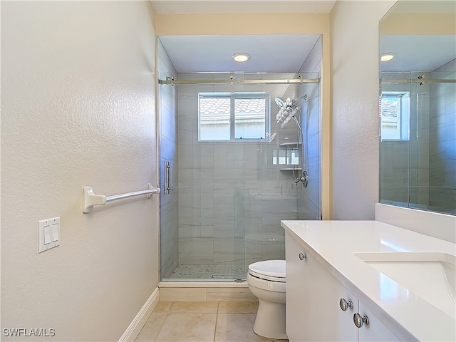 bathroom with tile patterned floors, vanity, toilet, and a shower with door