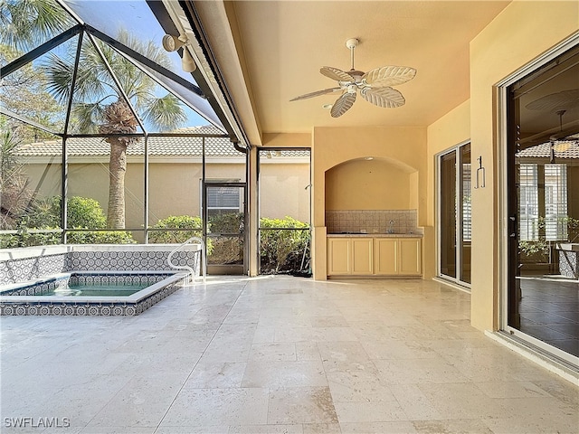 view of patio featuring a lanai, ceiling fan, and an in ground hot tub