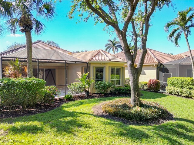 mediterranean / spanish-style home featuring a front lawn and a lanai