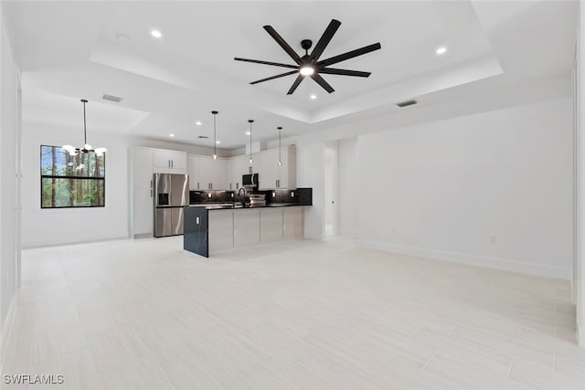 kitchen featuring white cabinets, pendant lighting, a raised ceiling, and stainless steel appliances