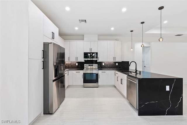 kitchen featuring white cabinetry, sink, backsplash, decorative light fixtures, and appliances with stainless steel finishes