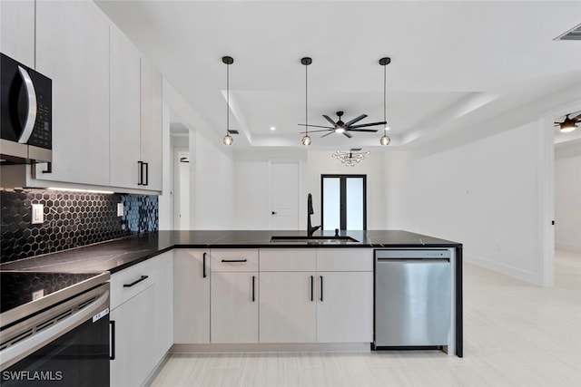 kitchen featuring appliances with stainless steel finishes, decorative light fixtures, white cabinetry, and sink