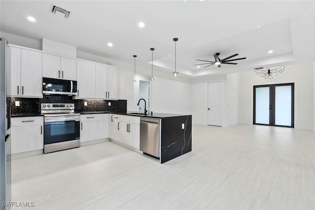 kitchen with white cabinetry, ceiling fan, sink, stainless steel appliances, and pendant lighting