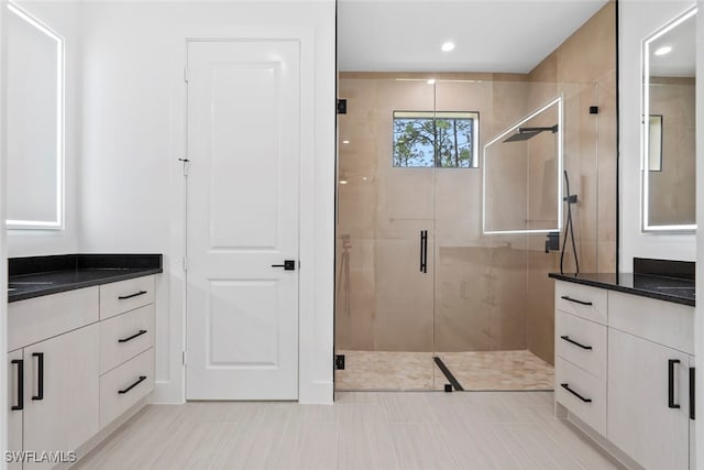 bathroom with vanity and a shower with door