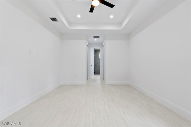 spare room featuring a tray ceiling and ceiling fan