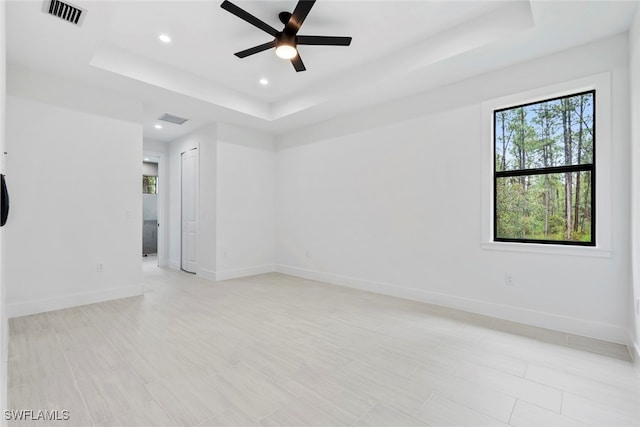 spare room featuring a raised ceiling and ceiling fan