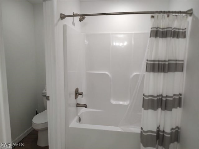 bathroom with shower / bath combination with curtain and toilet