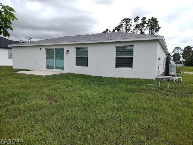 back of house with a lawn and a patio area