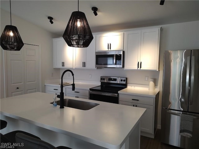 kitchen featuring pendant lighting, stainless steel appliances, white cabinetry, and sink