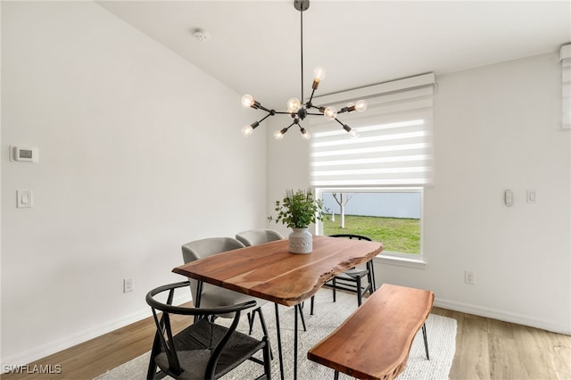 dining area featuring a notable chandelier, baseboards, and wood finished floors